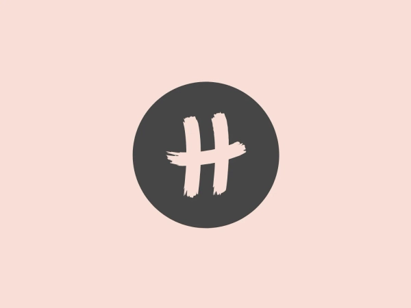 The Running Heroes logo features a white hash symbol (#) centered on a vibrant orange circular background. The irregular, brushstroke-like edges of the hash symbol give the design an organic and handcrafted feel, while the bright orange hue of the circle adds an energetic and eye-catching backdrop. The use of negative space within the hash symbol adds depth and dimension to this modern, accessible logo with an artistic touch.