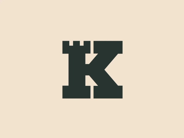 The logo for Keep Network incorporates a bold, dark gray "K" seamlessly merged with the silhouette of a castle turret at the top left corner. The design utilizes sharp angles and straight lines, creating a sturdy, fortified appearance associated with medieval architecture. The merger of the letter with the castle element emphasizes stability and strength. The simplicity of the color and form gives it a modern, clean look that would stand out against a light, subtle background.