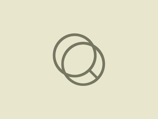 The A Equipa logo features a pair of interconnected rings, with the left ring overlapping the right. Both rings are smooth and have a consistent width, giving the design a sleek and modern look. The color of the logo is a muted, earthy shade, akin to sage or grayish-olive, which conveys an organic and natural vibe. The simplicity of the shapes and the subtlety of the color allow the logo to evoke a sense of harmony and balance, suitable for a brand aiming for a clean and minimalist aesthetic.