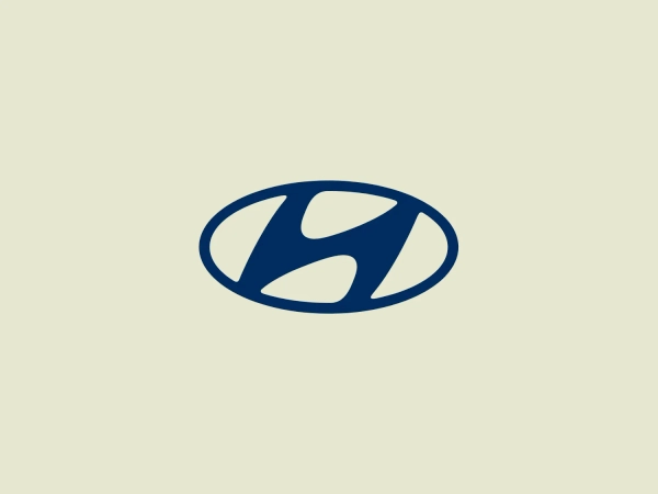 The Hyundai logo features a stylized oval shape in a deep blue color. Within the oval, there is an abstract design that resembles a dynamic letter 'H' or swirls cutting through the oval, with the negative space creating the impression of movement or speed. The shapes within the oval have rounded edges, contributing to a modern and streamlined aesthetic. This logo has a simple yet bold appearance, making it versatile for various applications. The blue color is vivid and professional, suggesting trust and reliability.