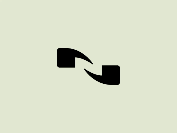 The Nuance Communications logo presents a minimalist abstract design with two bold black shapes resembling geometric arrows or chevrons pointed toward each other. The larger left shape serves as the main element, while the slightly smaller right shape complements it, creating a dynamic and engaging effect. Against a white background, the solid black design stands out with high contrast. The logo's clean lines and absence of additional embellishments contribute to its modern and professional appearance.