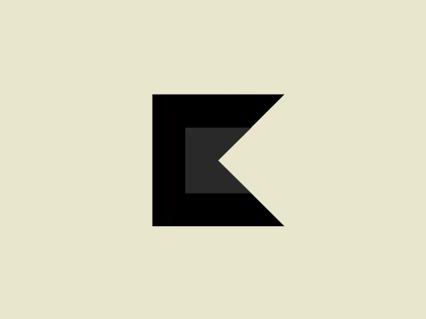 What catches our eye is the bold black letter 'K' forming the central element, enhanced by the dynamic angle and the small contrasting red triangle which adds movement to the design.
