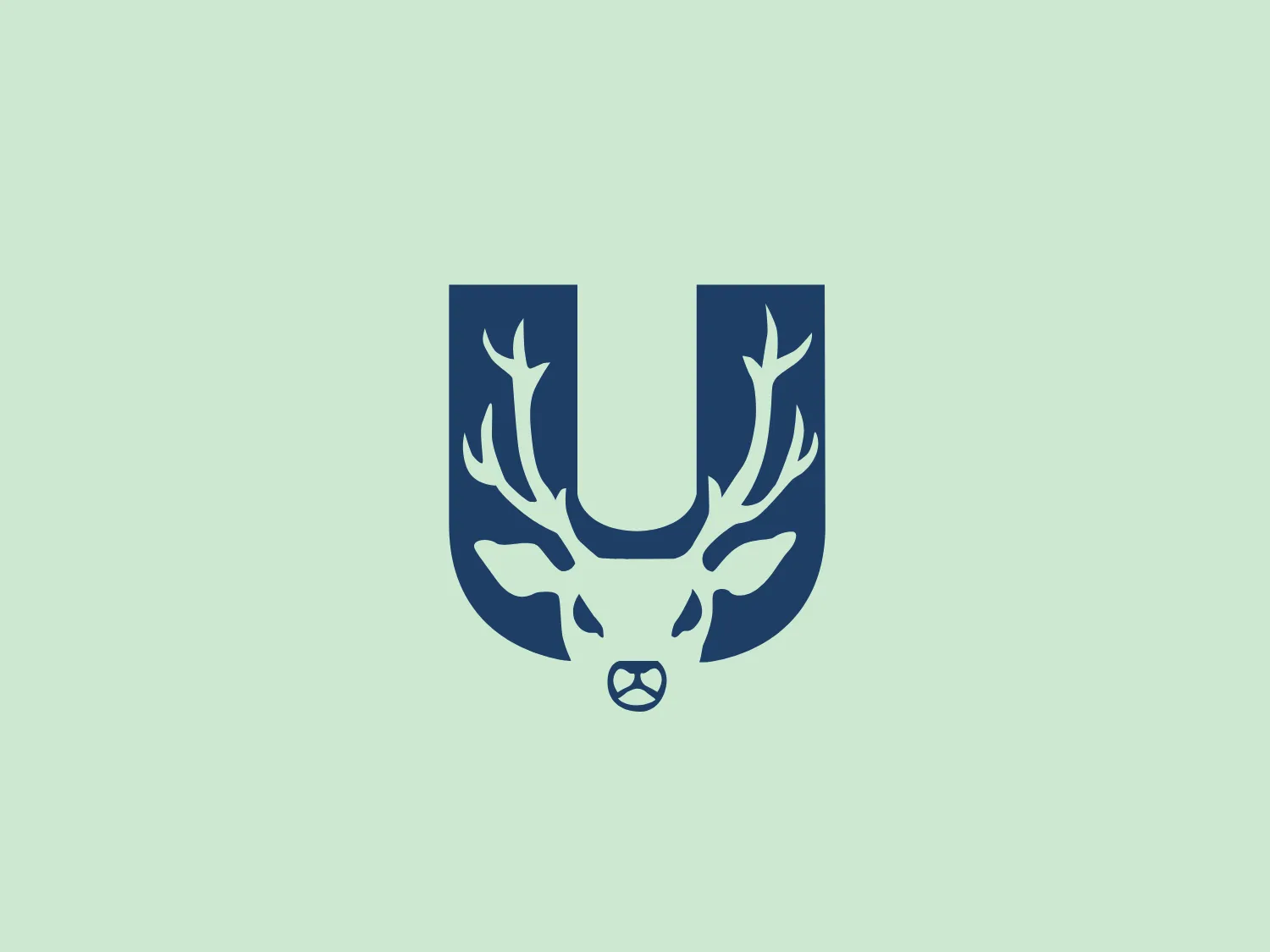 The Universidad Marista logo features a stylized depiction of a shield shape with a dark blue color palette. Inside the shield, there is a striking white design resembling animal antlers that frame a subtly integrated letter 'U' in the center. The antlers are symmetric with intricate branching, suggesting a sense of strength and stability. The overall design aesthetic is modern and minimalistic, with clean lines and a bold use of negative space to create the distinguishing features of the logo. The design conveys a sense of prestige and reliability, which would resonate well for brands associated with outdoors, nature, or heritage.