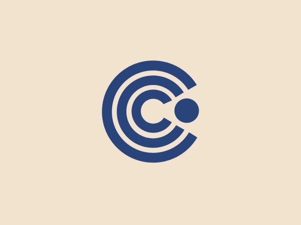 The Cimaco logo features a modern and abstract design with three concentric circles decreasing in thickness from the outermost to the inner circle. Inside the circles, there is a unique element that seems to be a combination of a dot and a small crescent shape, aligned off-center towards the upper-left quadrant, creating a dynamic and forward-moving appearance. This element interrupts the continuity of the circles on one side, suggesting connectivity or targeting. The color is a solid, deep shade of blue, which conveys professionalism and trustworthiness. Overall, the logo has a clean, tech-savvy look with a minimalist aesthetic. Considering the color and design of the Cimaco logo, a light and neutral background would complement it well.