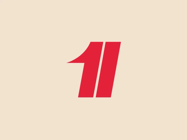 The logo presented by First National Bank of River Falls is a modern and stylized depiction of the number "11". It features two bold, vertical stripes with a bright red color which suggests vigor and attention-grabbing qualities. The left stripe is slightly angled at the top, creating an abstract representation of the number one, and giving a sharp dynamic look to the design. The right stripe is parallel to the left but without any angle, consistently representing the second "one" in the "11". The separation between the stripes is uniform, maintaining a clean and balanced aesthetic. The simplicity of the design gives it a versatile and contemporary feel, suitable for various branding contexts.