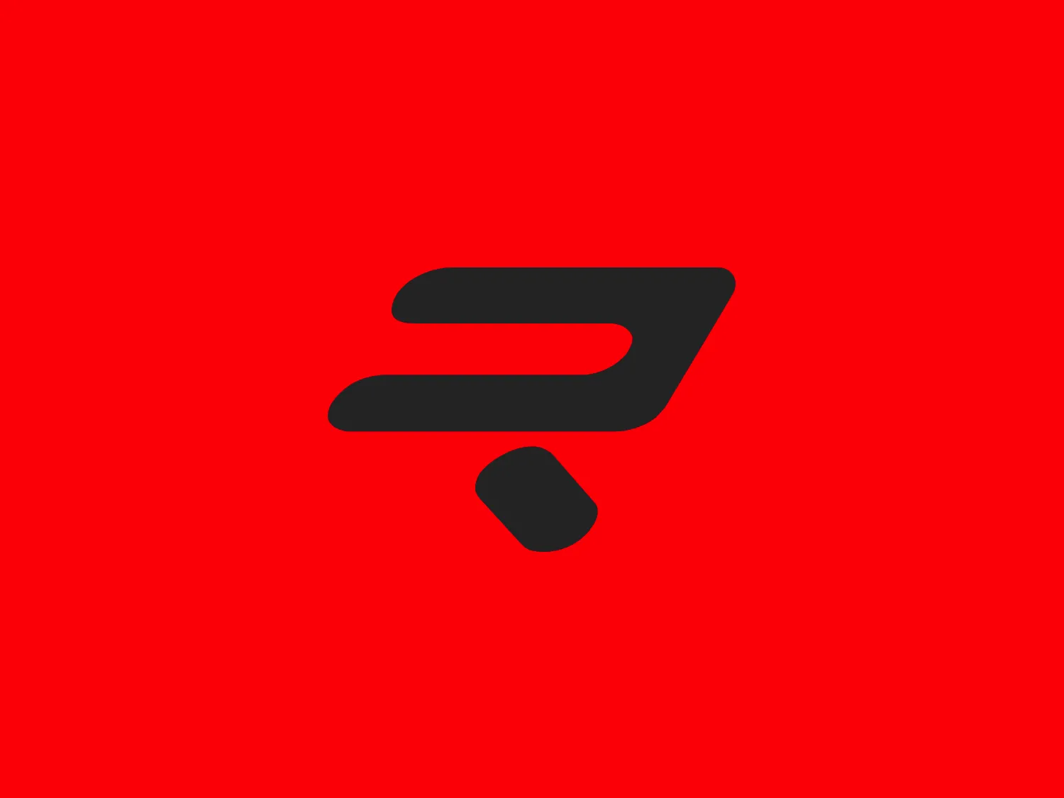 The Ridley Bikes logo features a bold, flat red color (#FF0000 or similar) with a composition of geometric shapes, including two elongated, curved elements that converge to a point on the right, giving it a sense of motion and speed. The upper shape is thick and broad, while the lower shape is thinner and tapers to a sharp angle, almost like a checkmark, and includes a detached, small rectangle at the bottom-left that suggests momentum or separation. The overall aesthetic conveys energy, modernity, and possibly denotes an association with technology, speed, or efficiency. The design is minimalist and uses negative space effectively to create the illusion of movement.