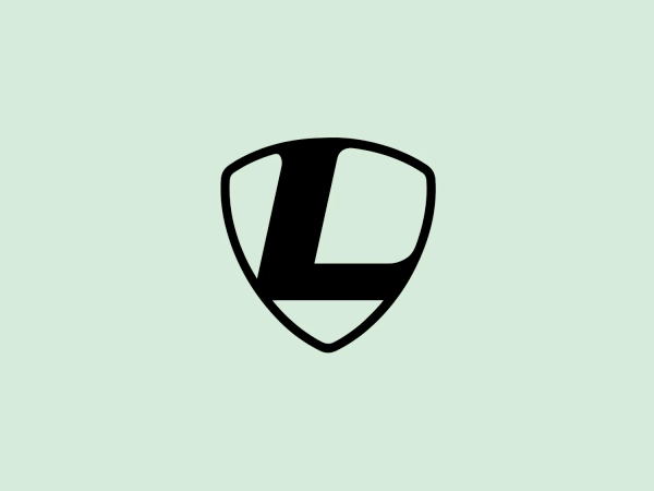 The Leader Bikes logo features a bold, minimalistic shield shape divided into three sections: a filled left segment, an empty central segment, and a filled right segment. Two diagonal lines separate the segments, meeting at the lower point of the shield to convey movement. The simple black and white color scheme offers visual impact and versatility, while the modern design suggests protection and strength commonly associated with a shield emblem.
