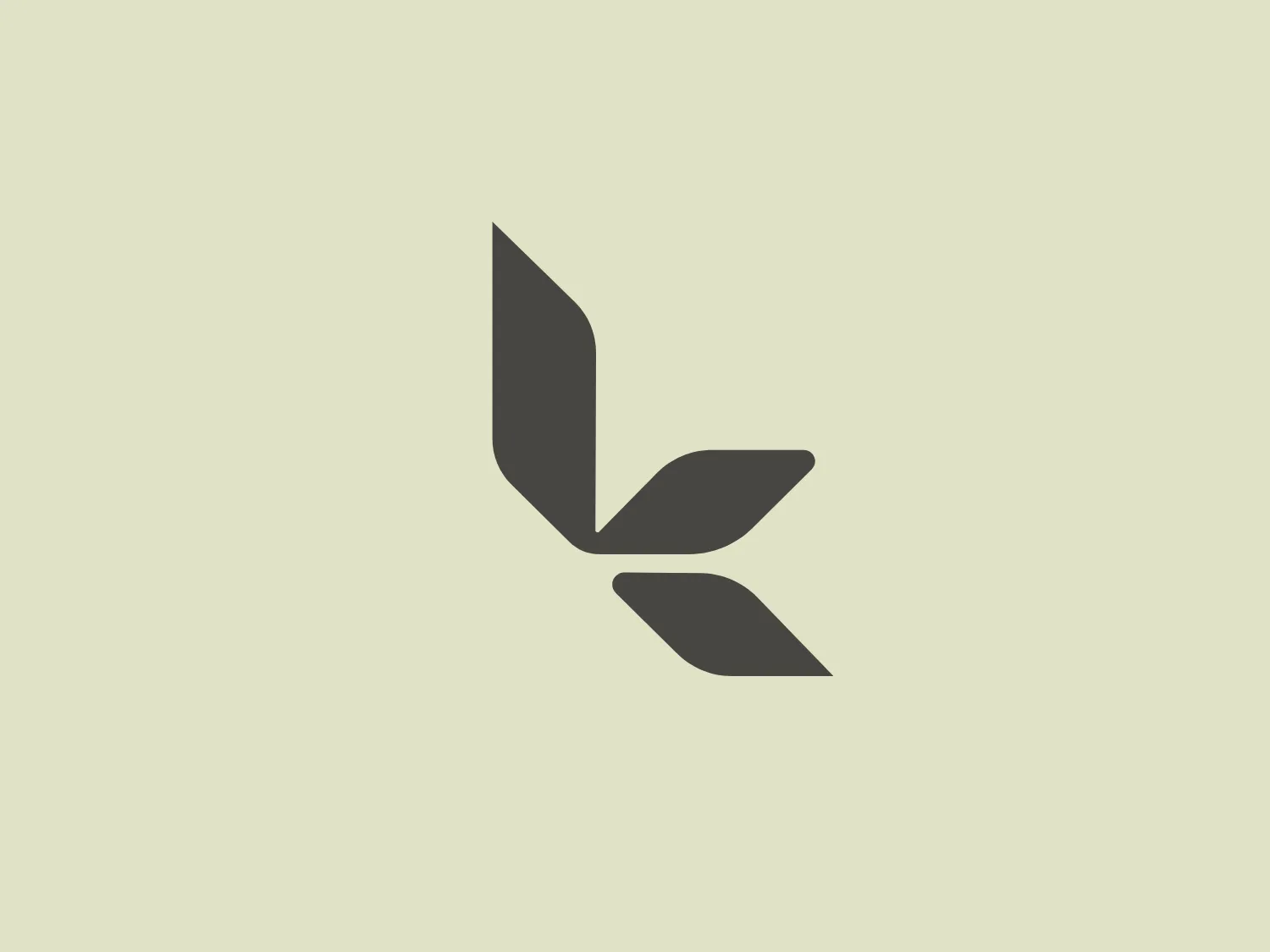 The Koolaburra logo features a minimalist and stylized depiction of a plant or flower, with three petals or leaves angled to create a sense of rotation or growth. The design is geometric and modern, using shades of muted gray for a sleek and professional look. The shape of the leaves is angular and sharp, which adds to the contemporary aesthetic. The simplicity of the design allows for a versatile use across various mediums.