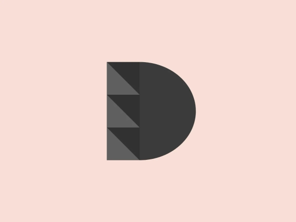 The image depicts a logo composed of a stylized letter "D" split vertically into two distinct sections. The right half of the "D" is a solid, vibrant red color, while the left side features a gradient of grays, separated into geometric triangular facets that create a three-dimensional effect, almost like a cut gem. The overall design aesthetic is modern and minimalistic, with a clear contrast between the simplicity of the red half and the intricacy of the faceted gray half. The clean lines and use of geometric shapes give the Divendi logo a professional and contemporary look.