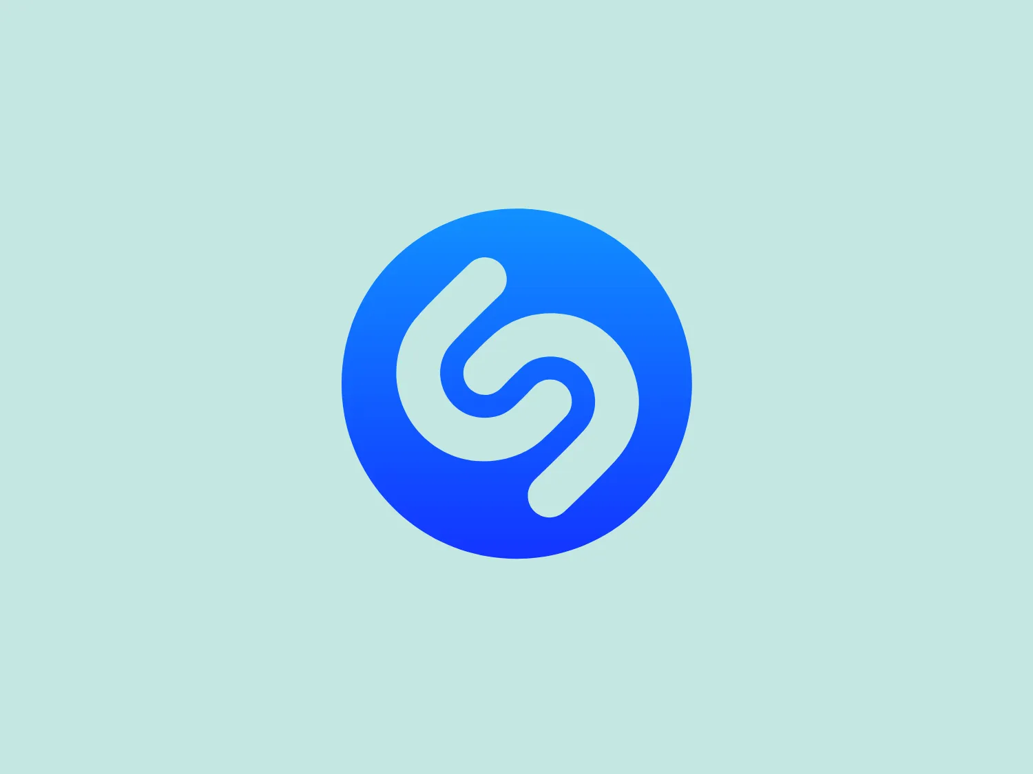 The Shazam logo is a stylized representation of a dynamic and fluid shape reminiscent of a swirl or a spiral, contained within a circle. It consists of two interconnected, thick, curved lines creating a sense of motion and connectivity. The logo employs a duo-tone color scheme, with the main symbol in white standing out against a vibrant, deep blue background. The overall design aesthetic is modern, clean, and suggests either movement, digital technology, or a creative, abstract concept. Additionally, there is a gradient effect within the blue circle, giving it a more three-dimensional look and adding depth to the design.