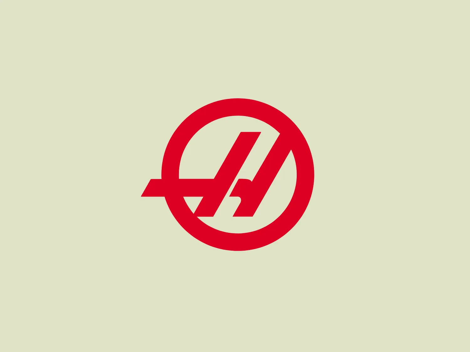 The Haas F1 Team logo features a circular shape with a diagonal cut that adds a sense of dynamism and forward motion. Inside the circle, there is a stylized lightning bolt that also signifies energy and speed, set against a clean white background, creating a stark contrast that makes the design stand out. The bold red color for the icon and the modern design aesthetic suggest that the brand represents power, technology, or high-speed services.